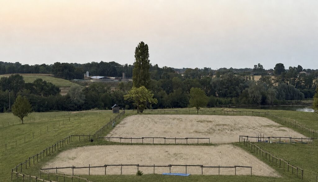 Vue des deux carrières des Écuries d'Eurofarm à Confrançon dans l'Ain, entourées de prairies et d'un environnement naturel.